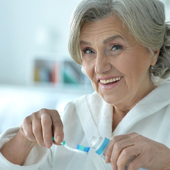 Patient in Glastonbury cleaning dentures at sink 