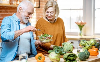 Older couple making a salad in their kitchen