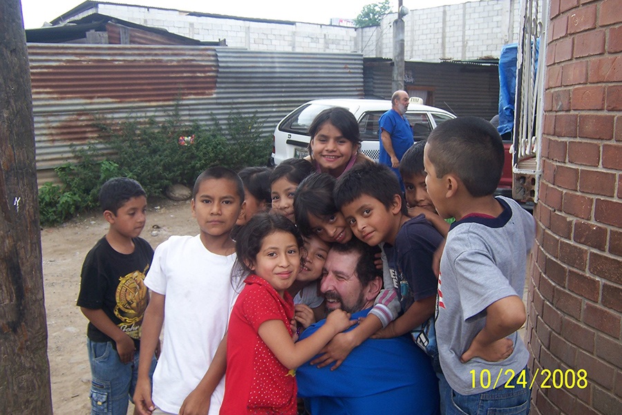 Young dental patients giving dentist a group hug