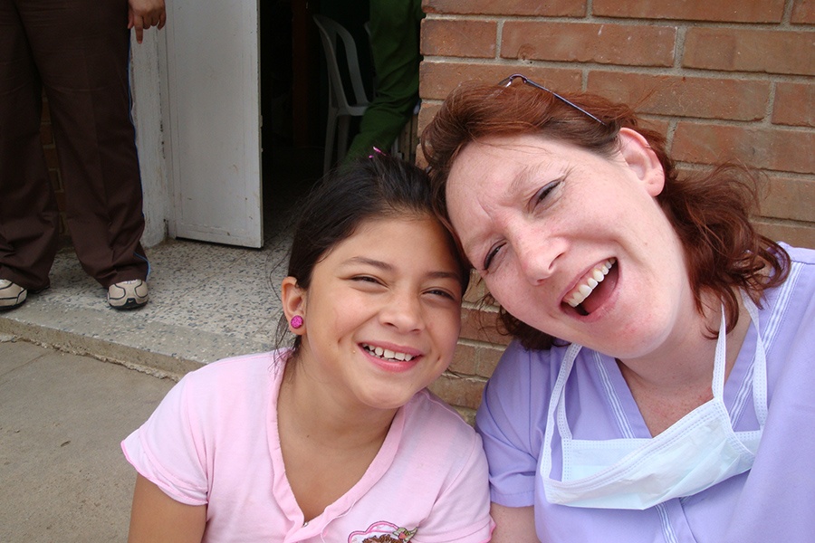 Dental team member and young patient laughing together