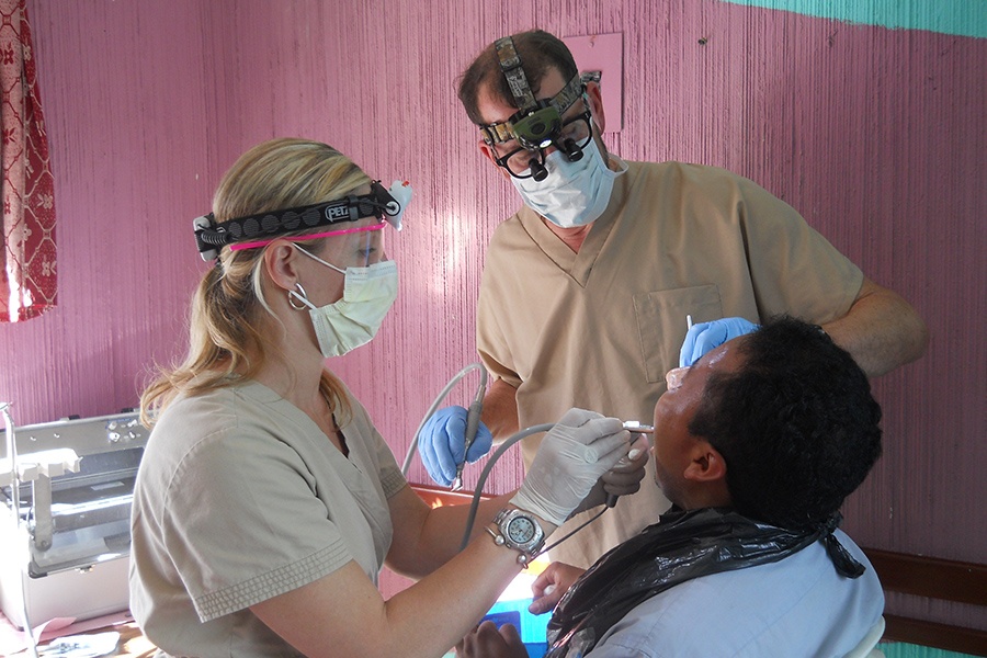 Dentist and dental team member treating dental patient