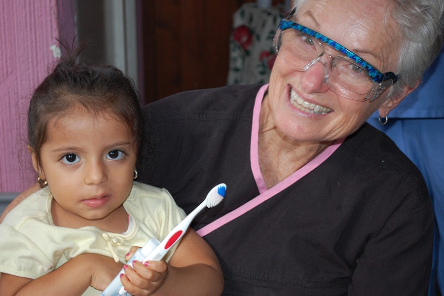 Dental team member holding toddler