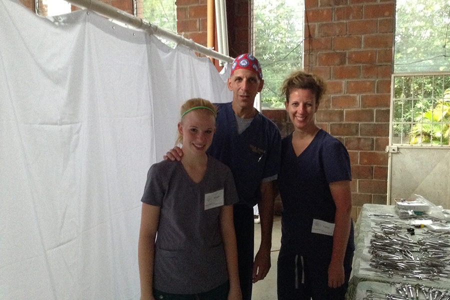 Dentist and two dental team members smiling together