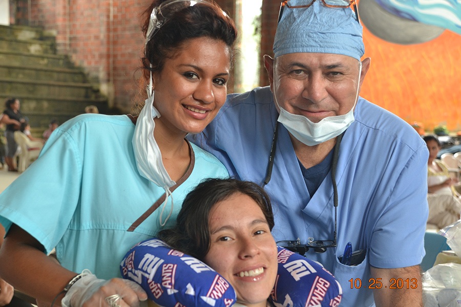 Dentist team member and dental patient smiling together