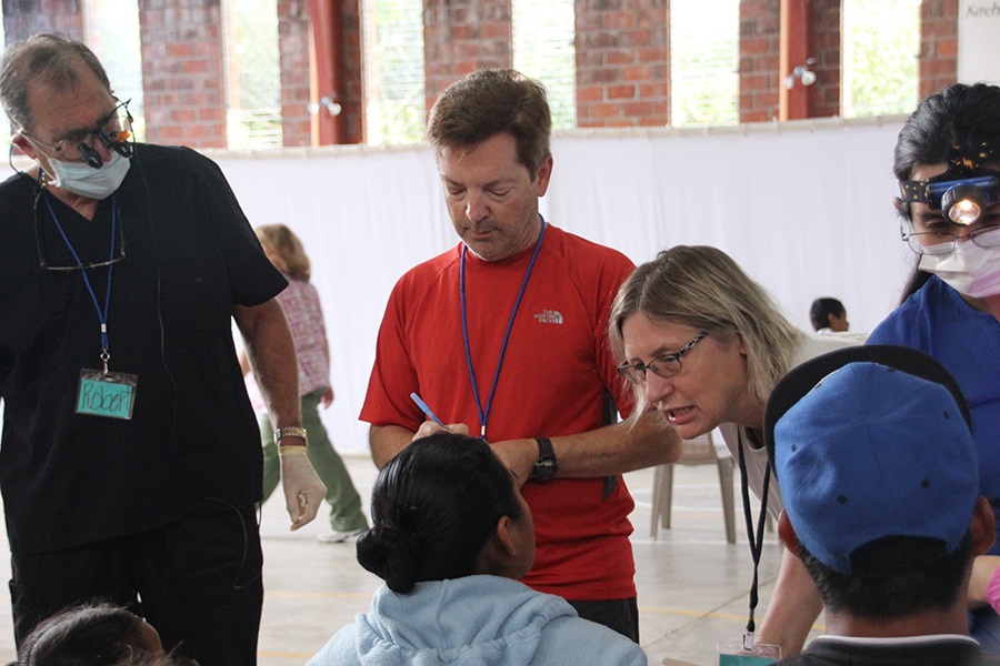 Dental team members talking to patients and taking notes