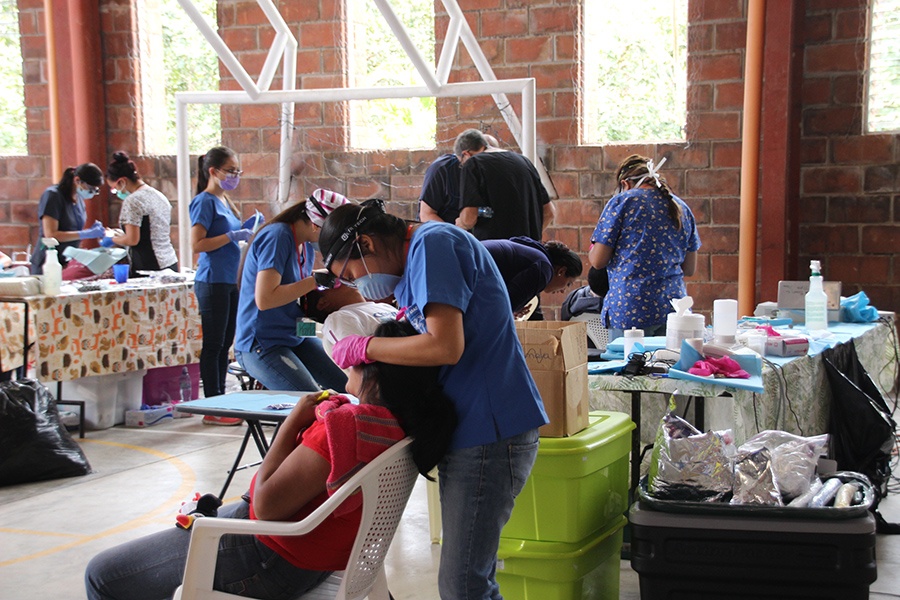 Row of chairs with patients being treated by dental team members