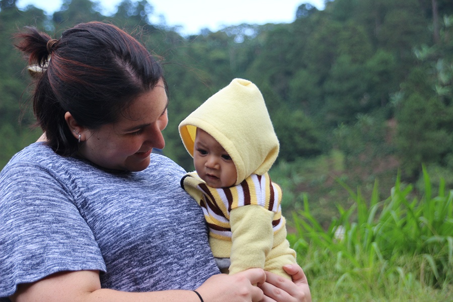 Woman holding an infant outdoors