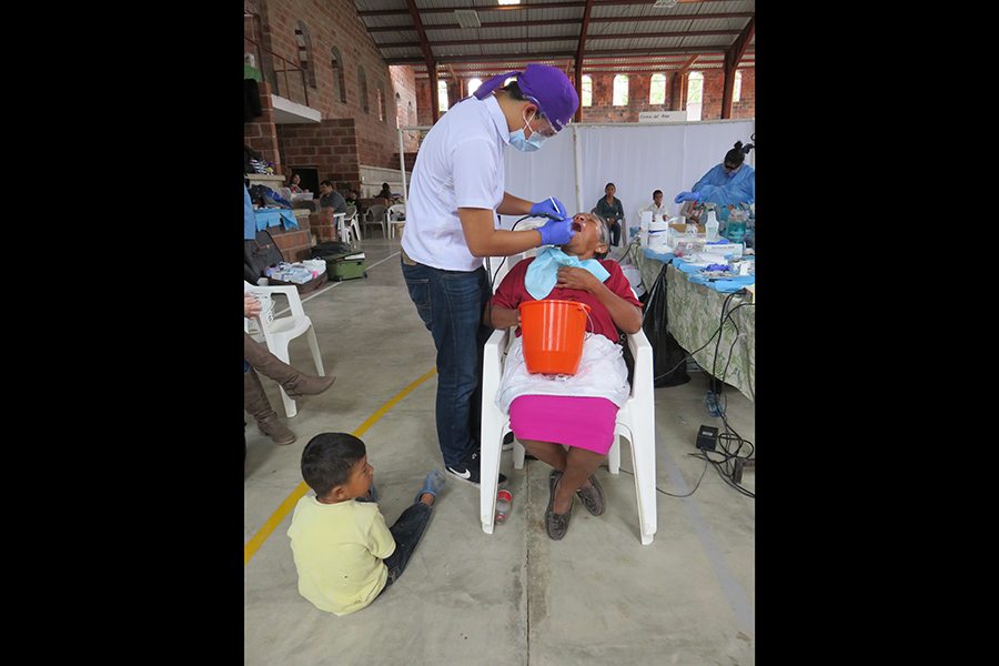 Dentist treating dental patient while young patient watches