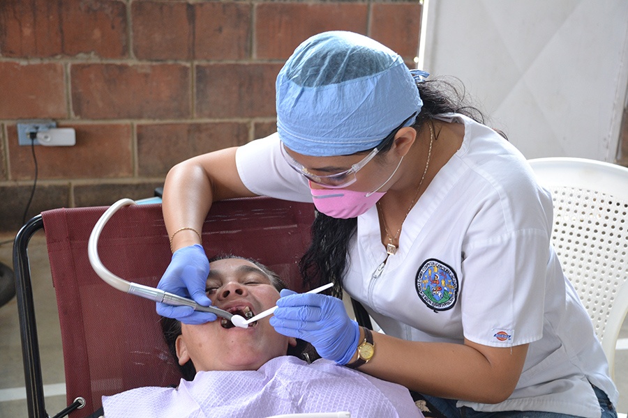 Dental team member examining child's decayed smile