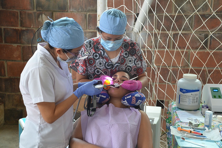 Two dental team members treating patient