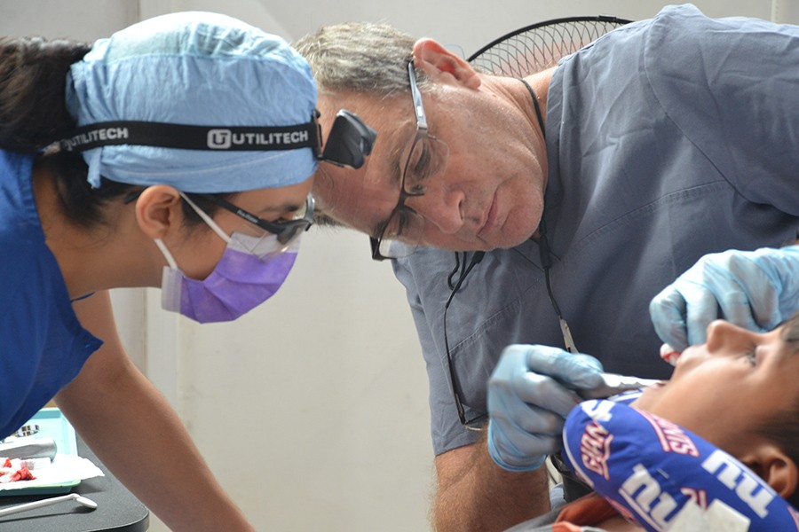 Dentist and team member looking at child's smile