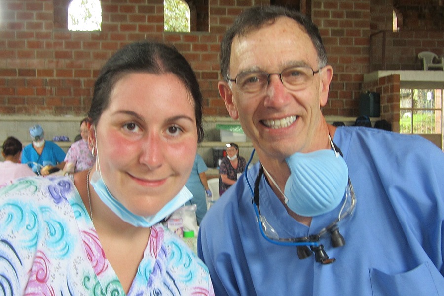 Dentist and team member smiling together on mission trip