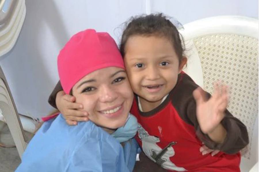 Dental team member getting a hug from a young patient