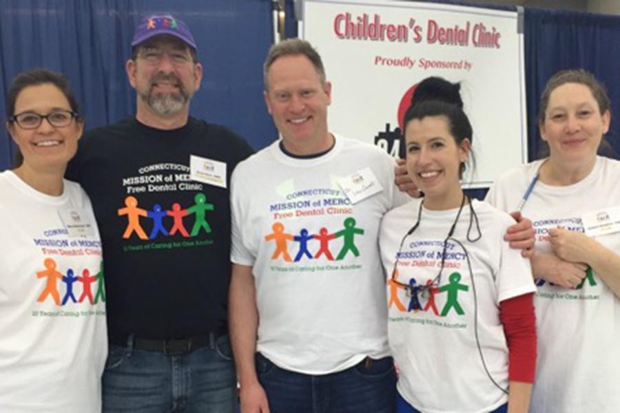 Five dental team members wearing Connecticut mission of mercy shirts