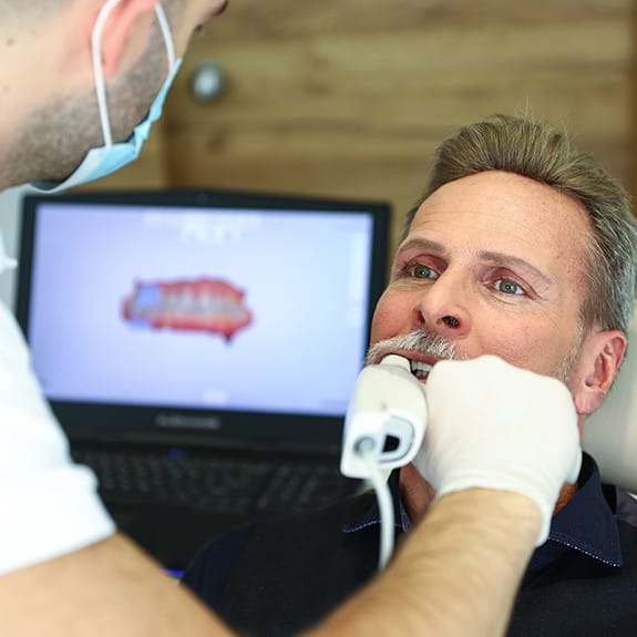 Dental team member using handheld smile camera