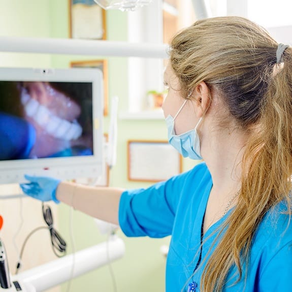 Dental team member looking at images captured with intraoral camera