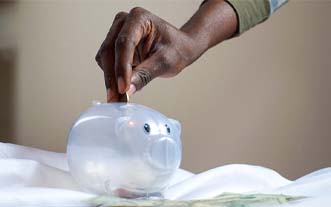 Man putting coin in piggy bank