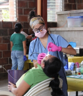 Dental team member treating dental patient at community event