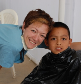 Dental team member smiling with young patient after dentistry treatment