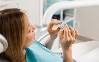 Patient holding clear aligner in treatment room