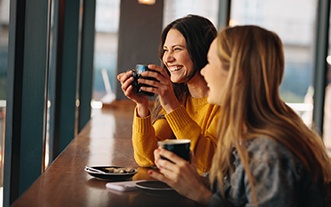 Two friends smiling in coffee shop