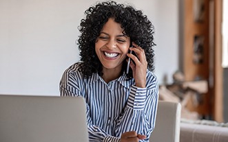 Woman smiling while talking on phone in office
