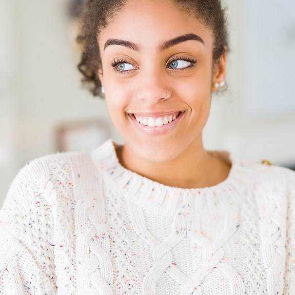 Woman at home smiling and wearing sweater