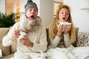 Couple with colds sneezing together.