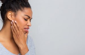 person holding their mouth because of a toothache