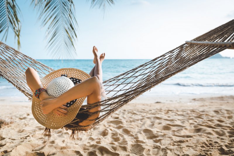 Woman relaxing in hammock by the beach